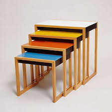 Serie de mesas de distinto tamaño y color que se embuten unas debajo de otras.